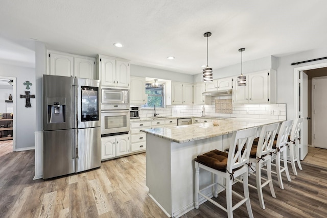 3206 S Fm 51, Decatur, TX 76234 - kitchen with appliances with stainless steel finishes, a sink, light stone countertops, a peninsula, and white cabinets