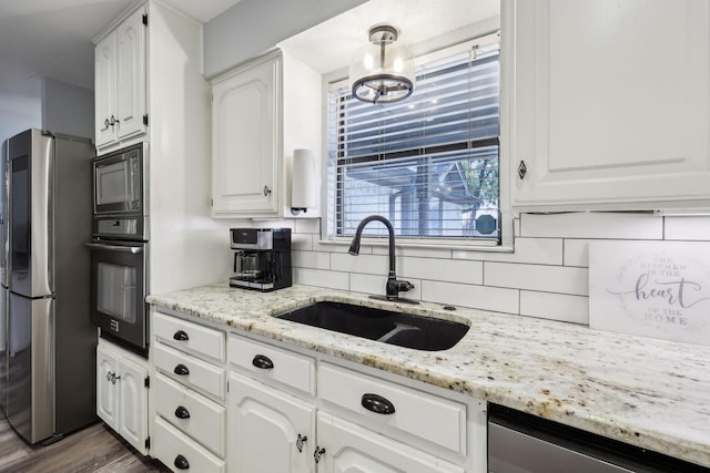 3206 S Fm 51, Decatur, TX 76234 - kitchen with stainless steel appliances, a sink, decorative backsplash, and white cabinetry