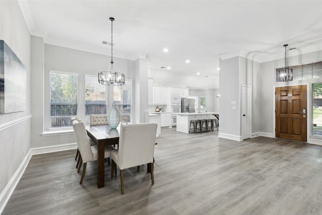 dining area with a chandelier, baseboards, ornamental molding, wood finished floors, and recessed lighting