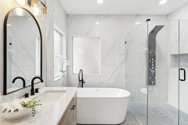 full bathroom featuring a stall shower, tile walls, a freestanding tub, vanity, and recessed lighting
