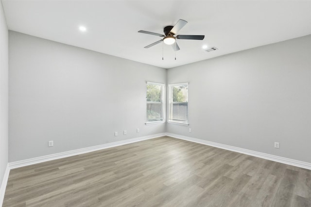 unfurnished room with light wood-style flooring, a ceiling fan, baseboards, and recessed lighting