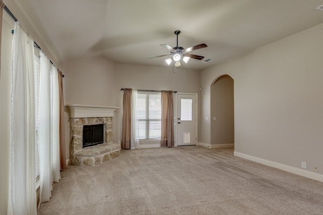 1002 Star Grass Dr, Mansfield, TX 76063 - unfurnished living room featuring a ceiling fan, a stone fireplace, arched walkways, light carpet, and baseboards