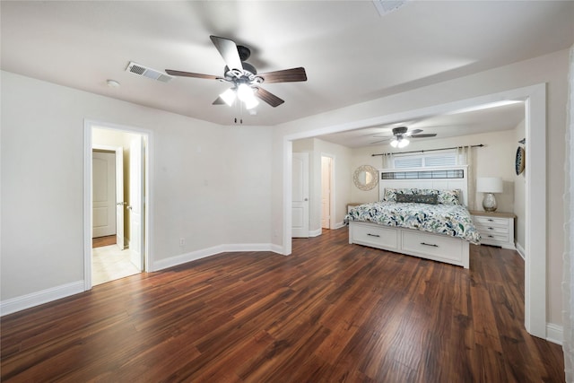 unfurnished bedroom featuring dark wood-style floors, baseboards, and a ceiling fan
