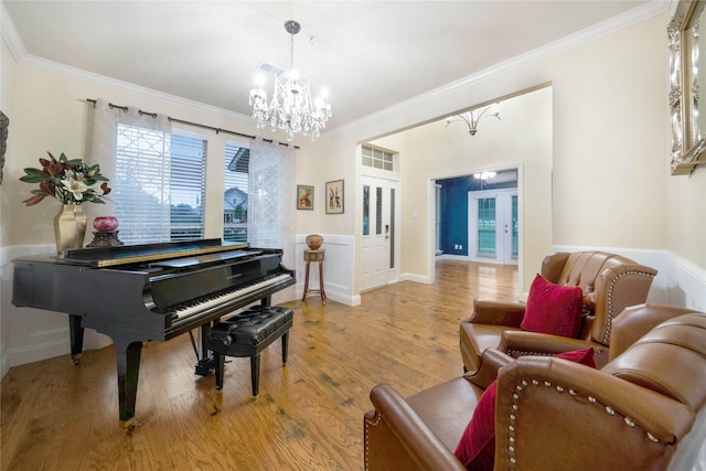 living area featuring a chandelier, ornamental molding, and light wood-style flooring