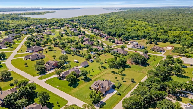 aerial perspective of suburban area featuring a large body of water and a heavily wooded area