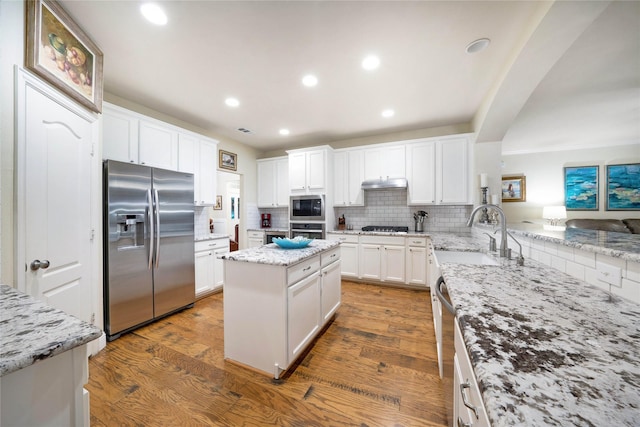 kitchen with stainless steel appliances, a sink, decorative backsplash, white cabinets, and recessed lighting
