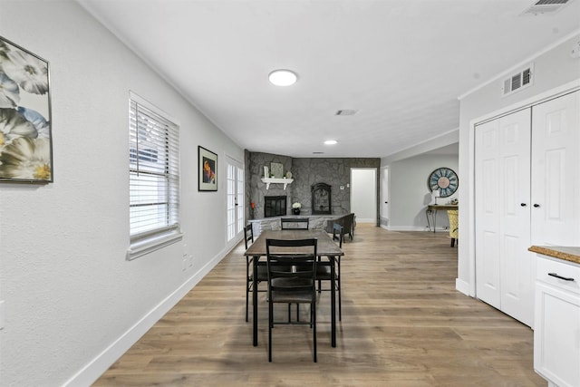 1846 Oak Hill Cir, Dallas, TX 75217 - dining room with a stone fireplace, wood finished floors, and baseboards