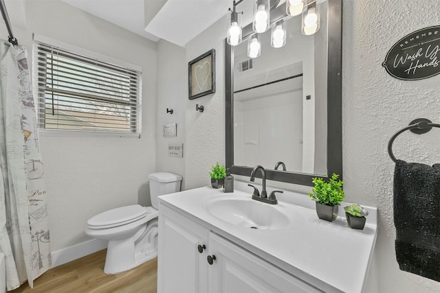 1846 Oak Hill Cir, Dallas, TX 75217 - bathroom with a textured wall, wood finished floors, toilet, vanity, and a shower with curtain