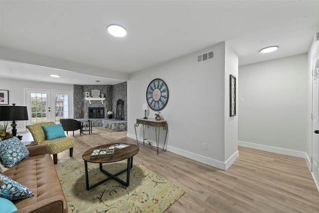 1846 Oak Hill Cir, Dallas, TX 75217 - living room featuring baseboards, light wood-style floors, and a stone fireplace