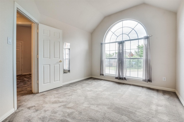 empty room with carpet floors, lofted ceiling, and baseboards