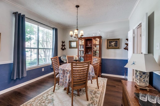 dining space with a chandelier, wood finished floors, a textured ceiling, baseboards, and crown molding