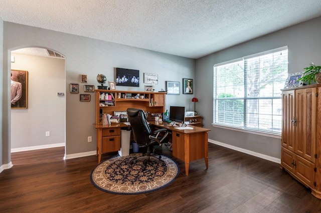 10557 Stargazer Dr, Frisco, TX 75033 - office featuring dark wood-style flooring, baseboards, a textured ceiling, and arched walkways