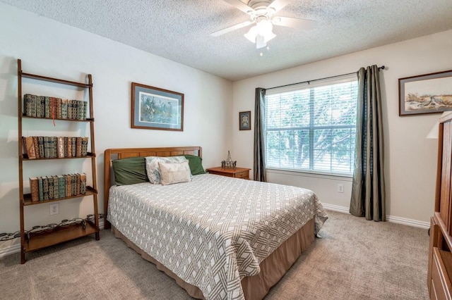 bedroom with light colored carpet, a textured ceiling, baseboards, and ceiling fan
