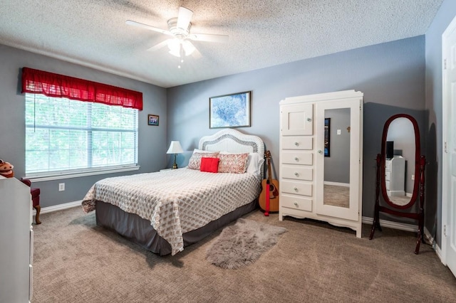 carpeted bedroom featuring a textured ceiling, a ceiling fan, and baseboards