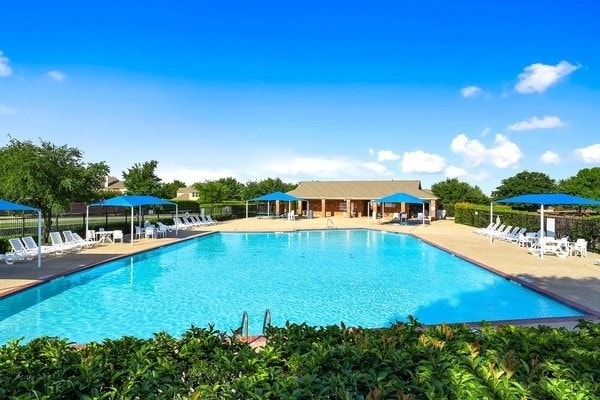 community pool featuring fence and a patio area
