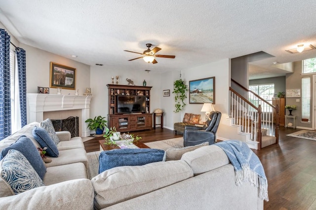 10557 Stargazer Dr, Frisco, TX 75033 - living room with dark wood-style floors, a ceiling fan, stairway, baseboards, and a textured ceiling