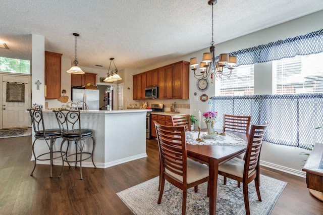 10557 Stargazer Dr, Frisco, TX 75033 - dining area with a textured ceiling, healthy amount of natural light, dark wood-style floors, and a chandelier