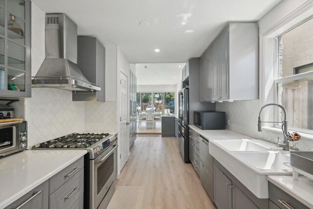4516 Mockingbird Ln, University Park, TX 75205 - kitchen featuring gray cabinets, stainless steel appliances, wall chimney range hood, a sink, and recessed lighting