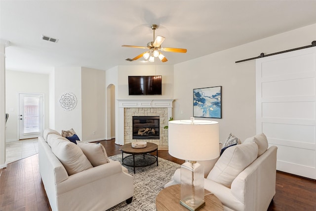 409 Rosemont Ln, Fairview, TX 75069 - living room featuring a ceiling fan, a barn door, dark wood-style floors, and arched walkways