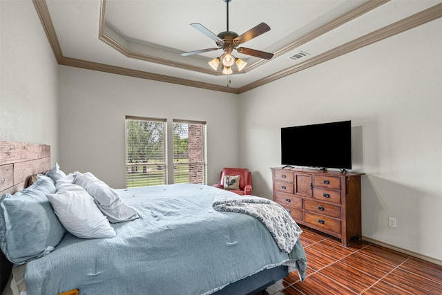 bedroom featuring a raised ceiling, ornamental molding, and ceiling fan