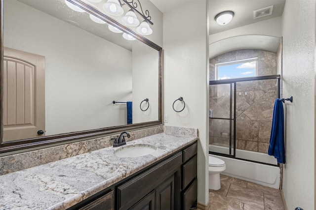 full bath with vanity, toilet, and combined bath / shower with glass door