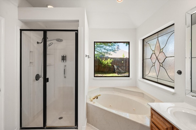 bathroom with a stall shower, a jetted tub, and vanity