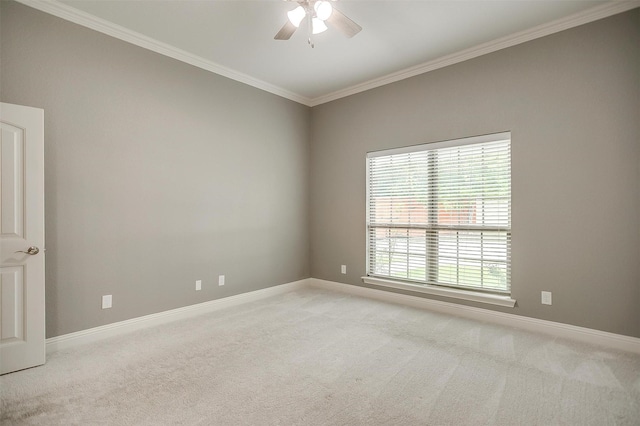 empty room featuring ceiling fan, light colored carpet, ornamental molding, and baseboards