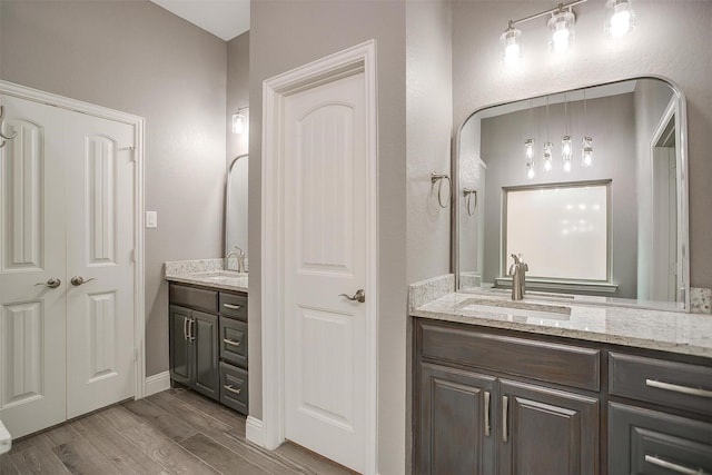 full bathroom featuring two vanities and wood finished floors