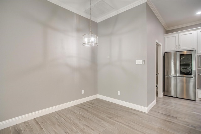 unfurnished dining area featuring ornamental molding, baseboards, light wood-style flooring, and a chandelier
