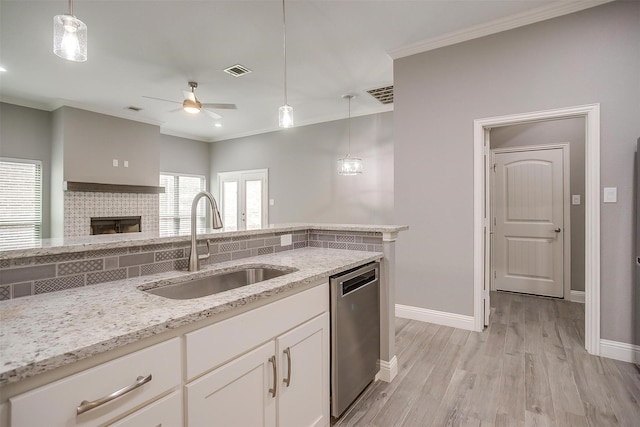 kitchen featuring a sink, dishwasher, a ceiling fan, crown molding, and hanging light fixtures