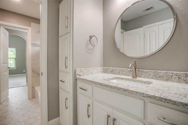 bathroom with vanity, tile patterned flooring, baseboards, and shower / tub combination