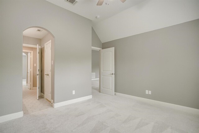 unfurnished bedroom featuring arched walkways, light colored carpet, baseboards, ceiling fan, and lofted ceiling