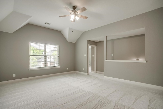 unfurnished room featuring a ceiling fan, light colored carpet, vaulted ceiling, and baseboards