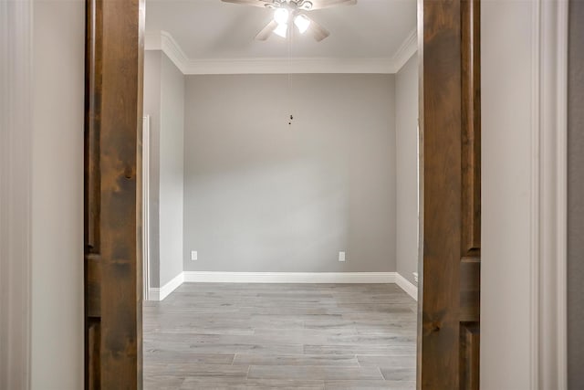 empty room featuring ceiling fan, wood finished floors, ornamental molding, and baseboards
