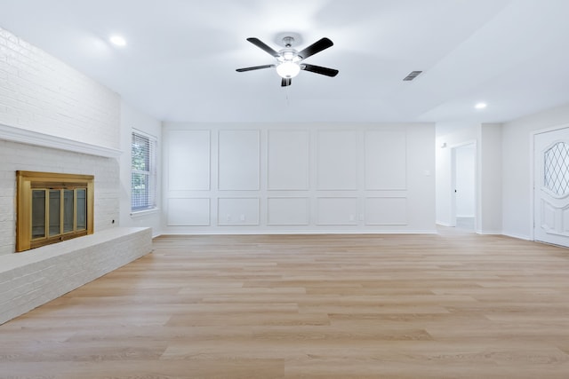 609 W Windsor Dr, Denton, TX 76207 - unfurnished living room with a ceiling fan, recessed lighting, a brick fireplace, light wood-style floors, and baseboards
