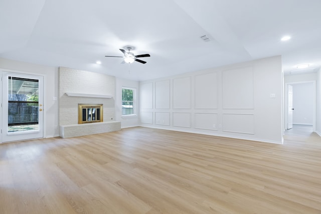 609 W Windsor Dr, Denton, TX 76207 - unfurnished living room with ceiling fan, light wood-style floors, a decorative wall, a brick fireplace, and recessed lighting