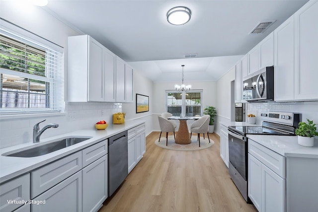 609 W Windsor Dr, Denton, TX 76207 - kitchen with appliances with stainless steel finishes, a sink, healthy amount of natural light, and a chandelier