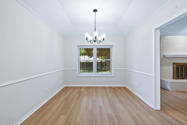 609 W Windsor Dr, Denton, TX 76207 - unfurnished dining area featuring wood finished floors, a chandelier, a brick fireplace, a raised ceiling, and baseboards