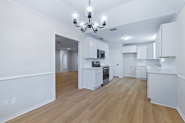 609 W Windsor Dr, Denton, TX 76207 - kitchen with stainless steel appliances, a chandelier, light wood-type flooring, light countertops, and white cabinets