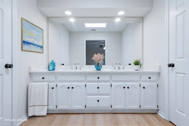 609 W Windsor Dr, Denton, TX 76207 - bathroom featuring wood finished floors, double vanity, baseboards, and ceiling fan