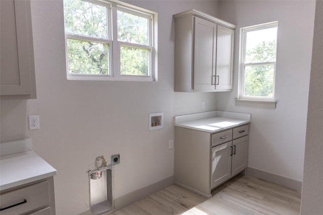 196 Jim Walter Dr, Runaway Bay, TX 76426 - laundry room with cabinet space, hookup for a washing machine, light wood-style flooring, and baseboards