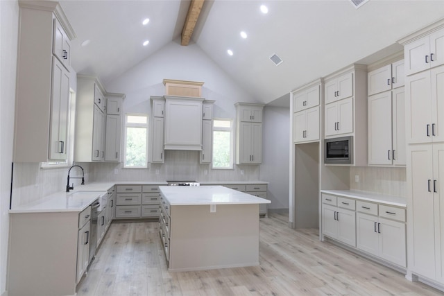 196 Jim Walter Dr, Runaway Bay, TX 76426 - kitchen with beam ceiling, a center island, decorative backsplash, appliances with stainless steel finishes, and light wood-style flooring