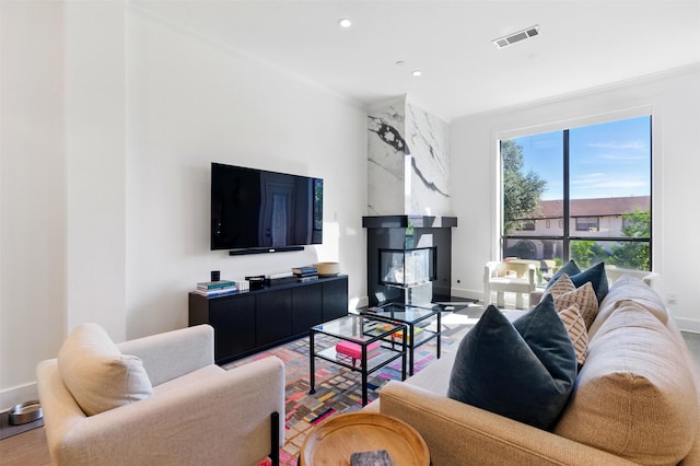living area with baseboards, wood finished floors, recessed lighting, and a premium fireplace