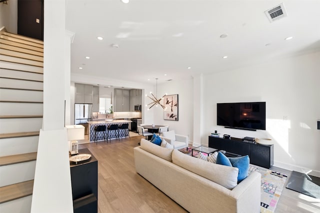 living room with stairway, light wood-style flooring, recessed lighting, and baseboards