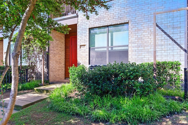 entrance to property featuring brick siding and a balcony