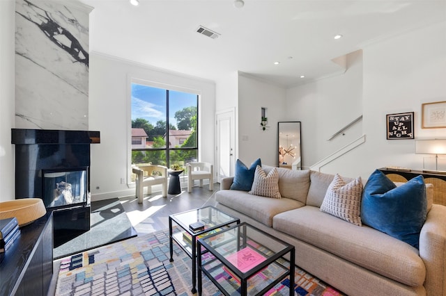 living area featuring crown molding, recessed lighting, a fireplace, and baseboards