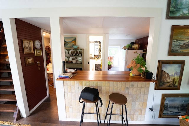 7006 Horseshoe Bend Trl, Weatherford, TX 76087 - kitchen with freestanding refrigerator, wood finished floors, and a kitchen breakfast bar