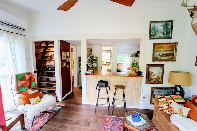 7006 Horseshoe Bend Trl, Weatherford, TX 76087 - living area featuring a ceiling fan, an AC wall unit, stairs, wood finished floors, and bar