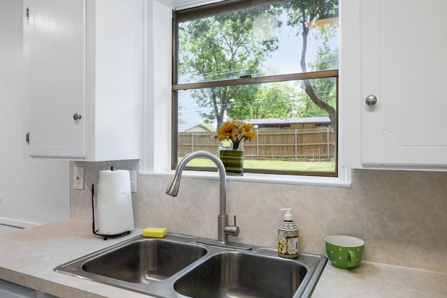 1710 Windsor Dr, Arlington, TX 76012 - kitchen view of a sink, white cabinetry, tasteful backsplash, and light countertops