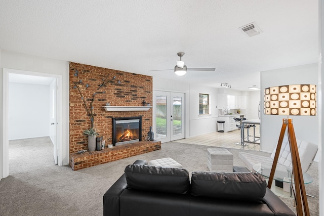 1710 Windsor Dr, Arlington, TX 76012 - living room with light carpet, a fireplace, ceiling fan, and a textured ceiling